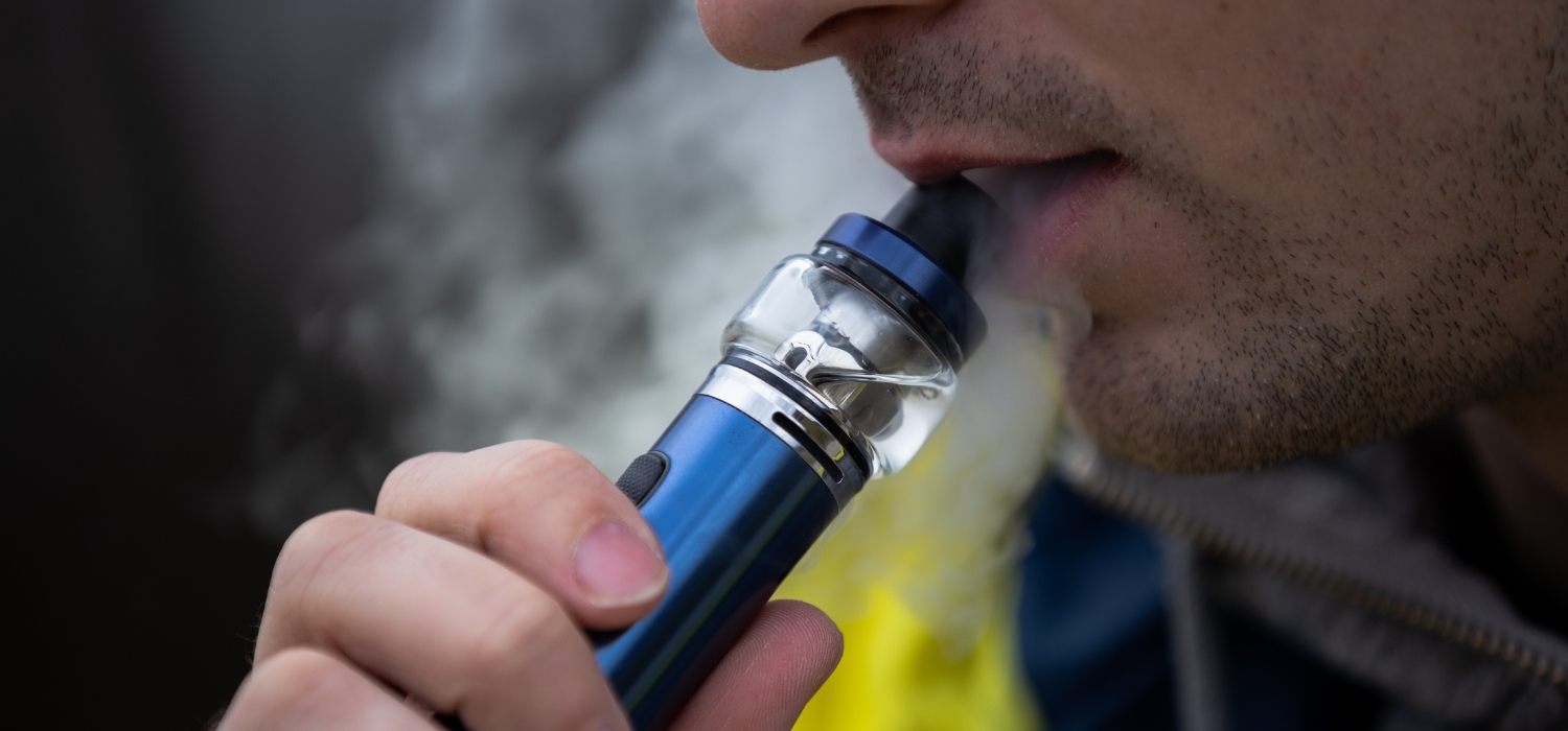 man vaping close up with unshaven face