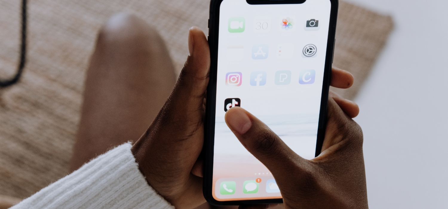 woman pressing tiktok app while sat on toilet