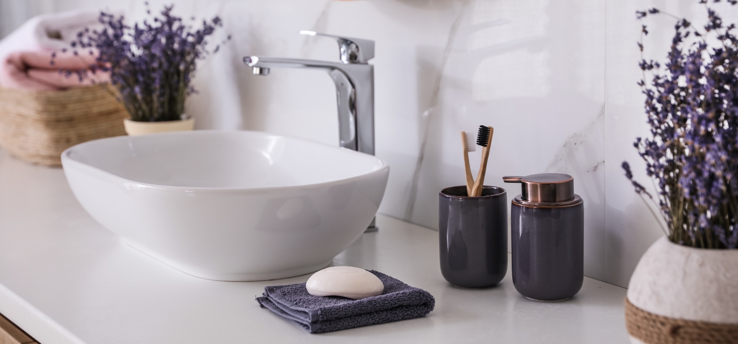 image of lavender bunches in vases in bathroom next to sink and soap