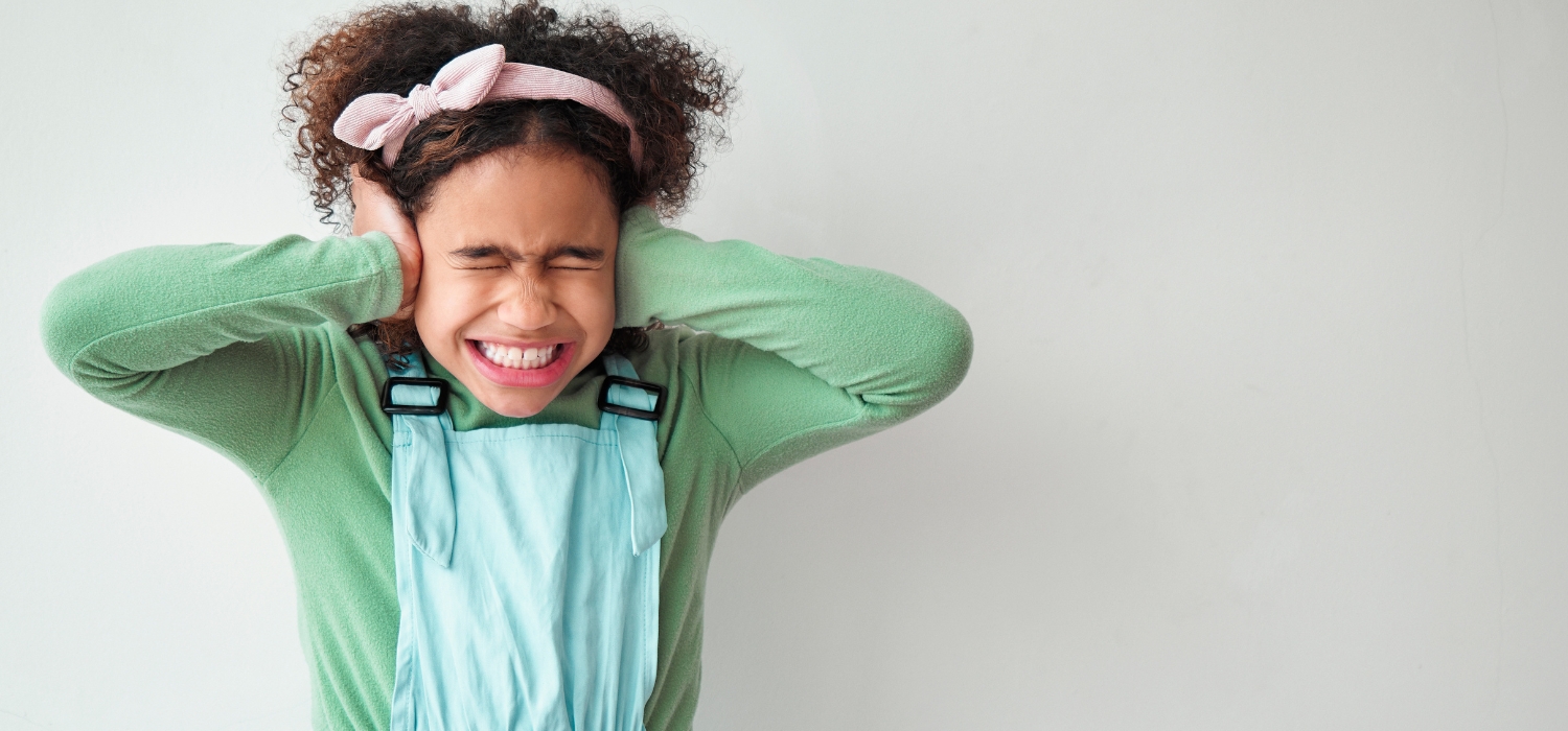 noise sensitive child with hands over ears