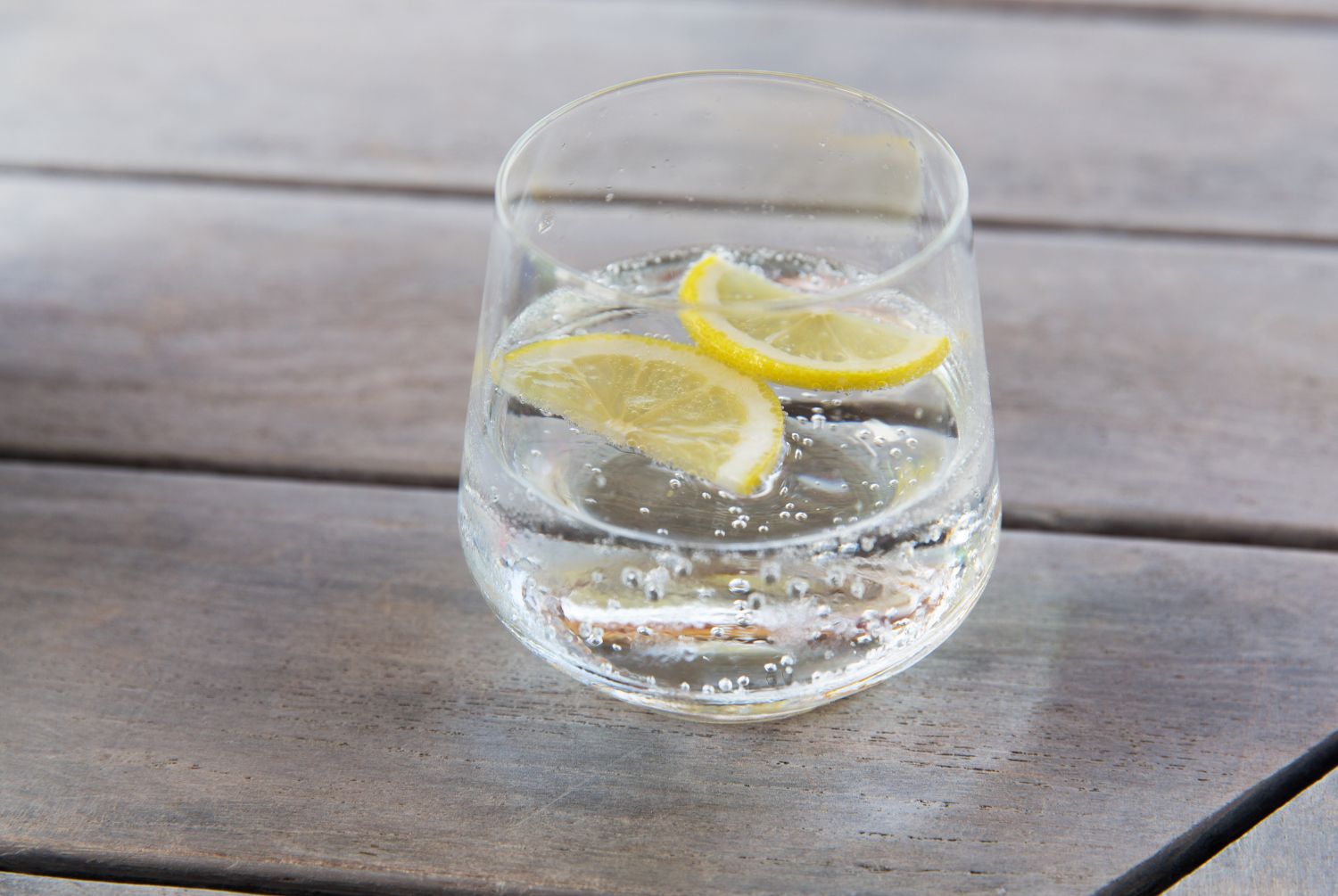 image of water in tumbler glass with slices of lemon