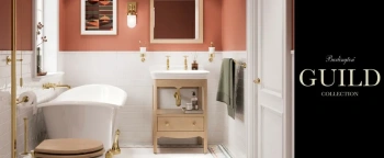 image of orange bathroom with freestanding bath and light oak vanity unit with black side and burlington guild logo