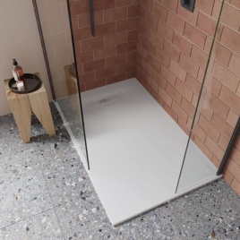 image of a crosswater rectangular shower tray fitted in walk in shower with brick walls and terrazzo grey floor